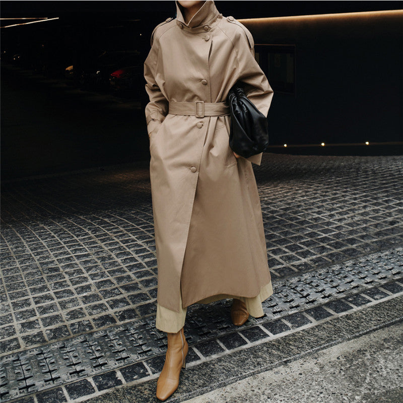 Women’s maxi-length trench coat with a high stand-up collar and waist belt